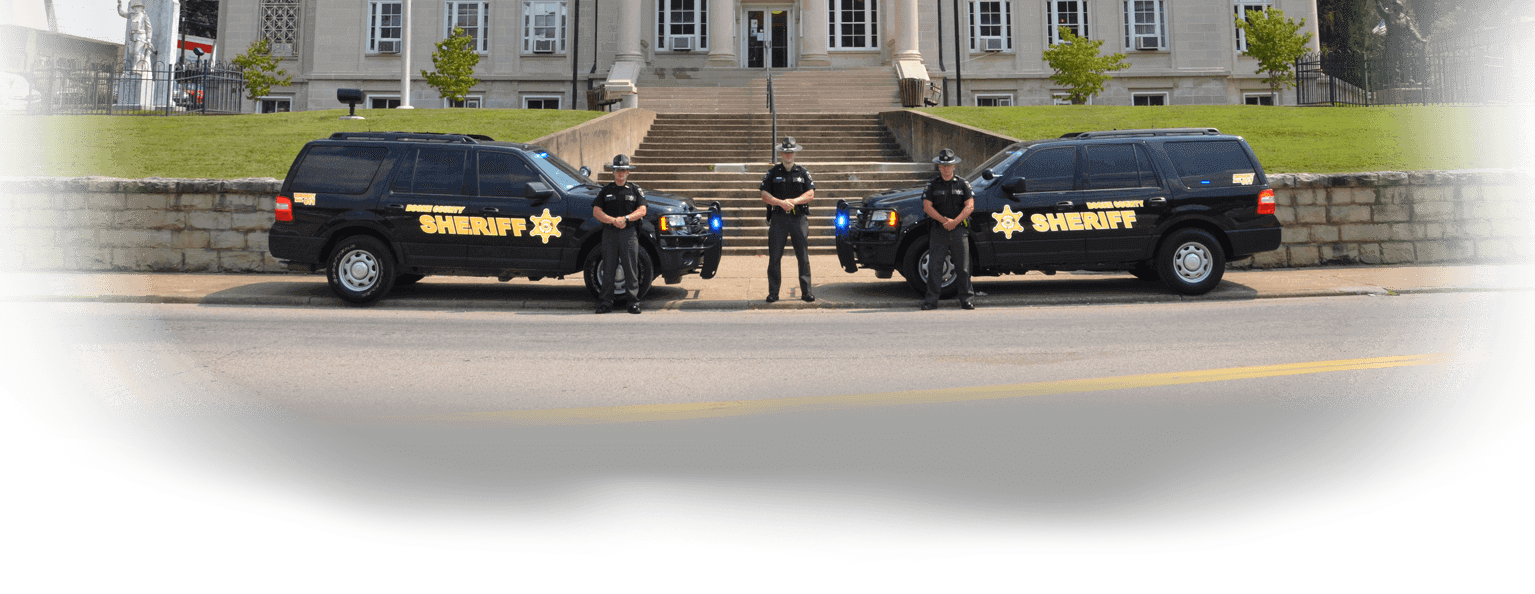 Image of the sheriffs posing in front of the house court with their vehicles.